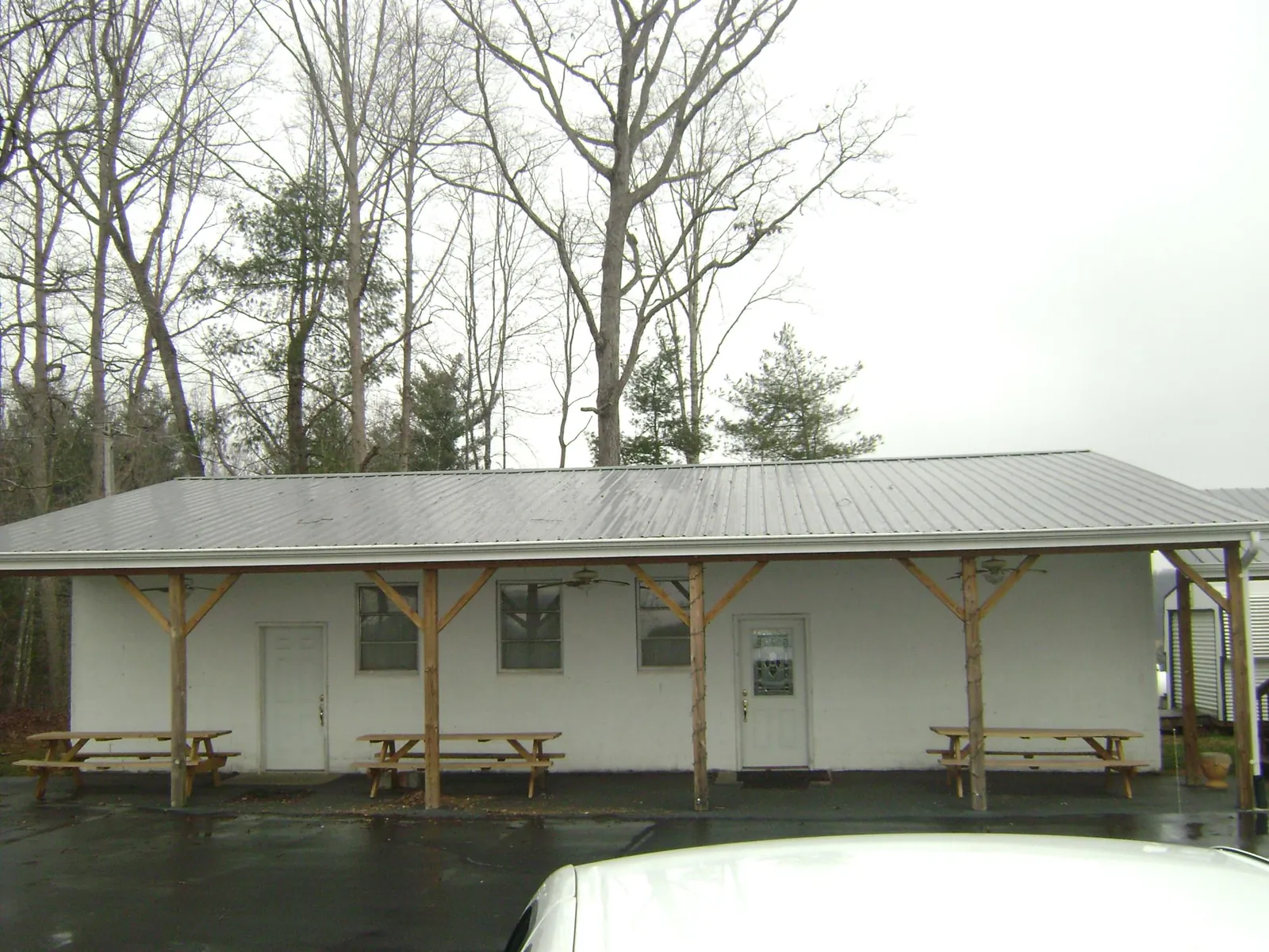 Gray metal roof over a block building with a timber post porch in Portsmouth